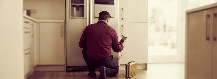 Technician checking a side-by-side refrigerator in a Cypress kitchen