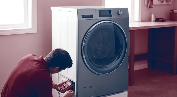 Technician testing a top-load washer in a laundry room