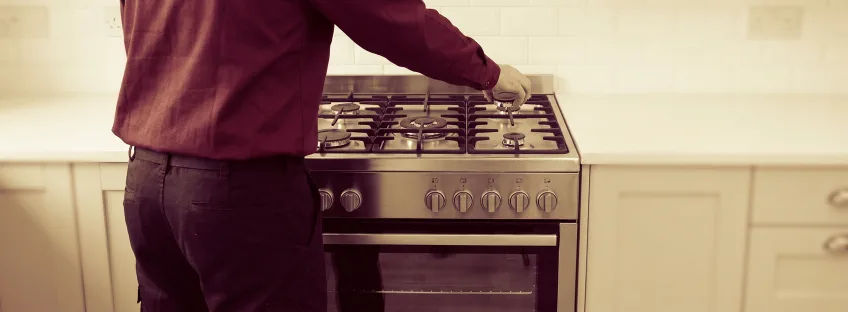 Technician adjusting a burner on a gas range