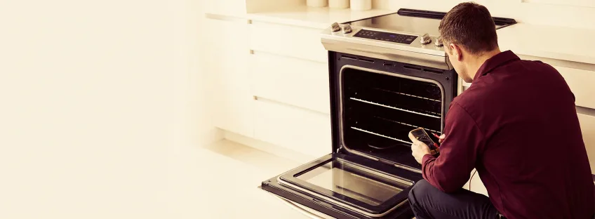 Technician checking the inside of an oven with the door open